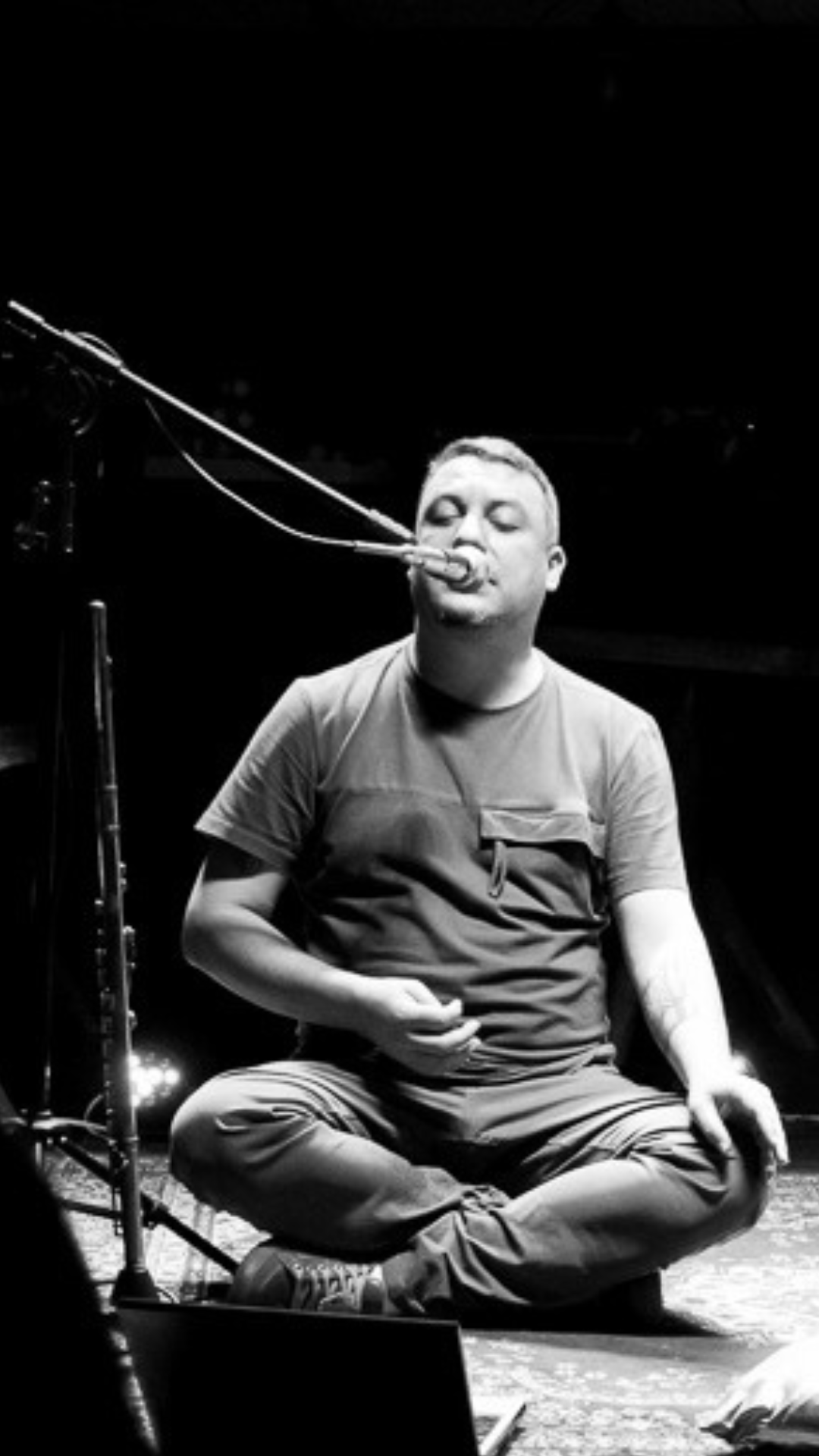 Jefferson Zambon Scherrer sentado no palco durante apresentação